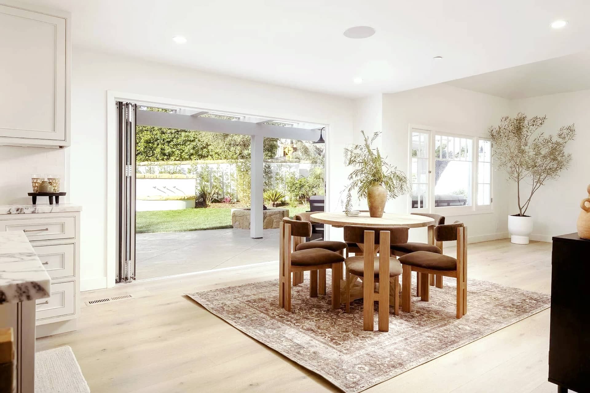 A Montecito dining room opening to the garden through folding doors.