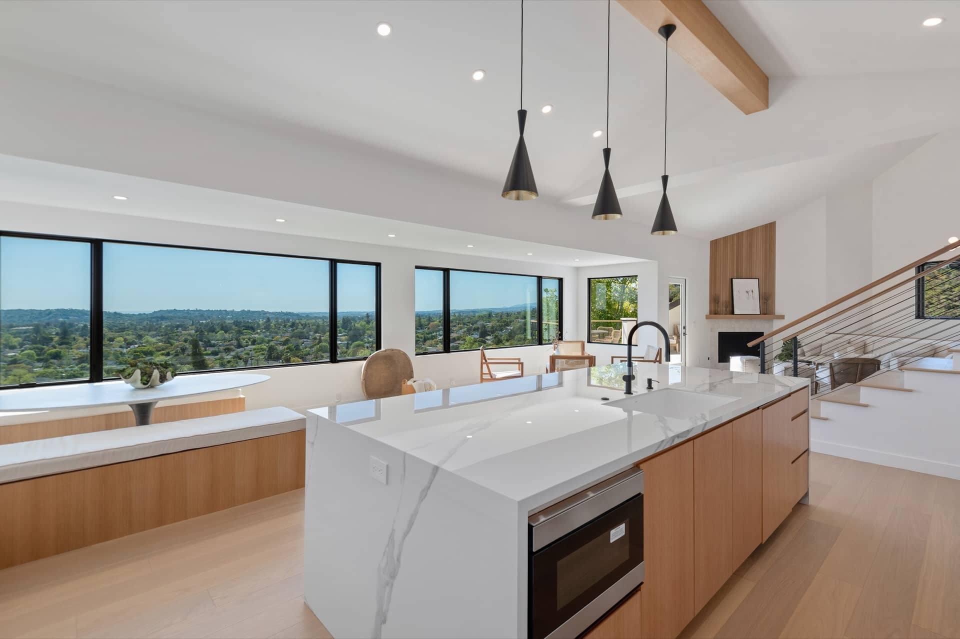A Riviera kitchen island under pendants, windows to the valley.
